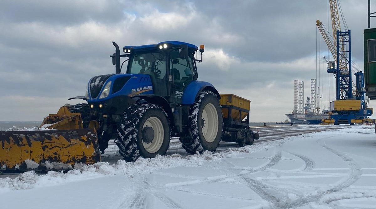 Industrial services - Tractor clearing snow and gritting a dock side